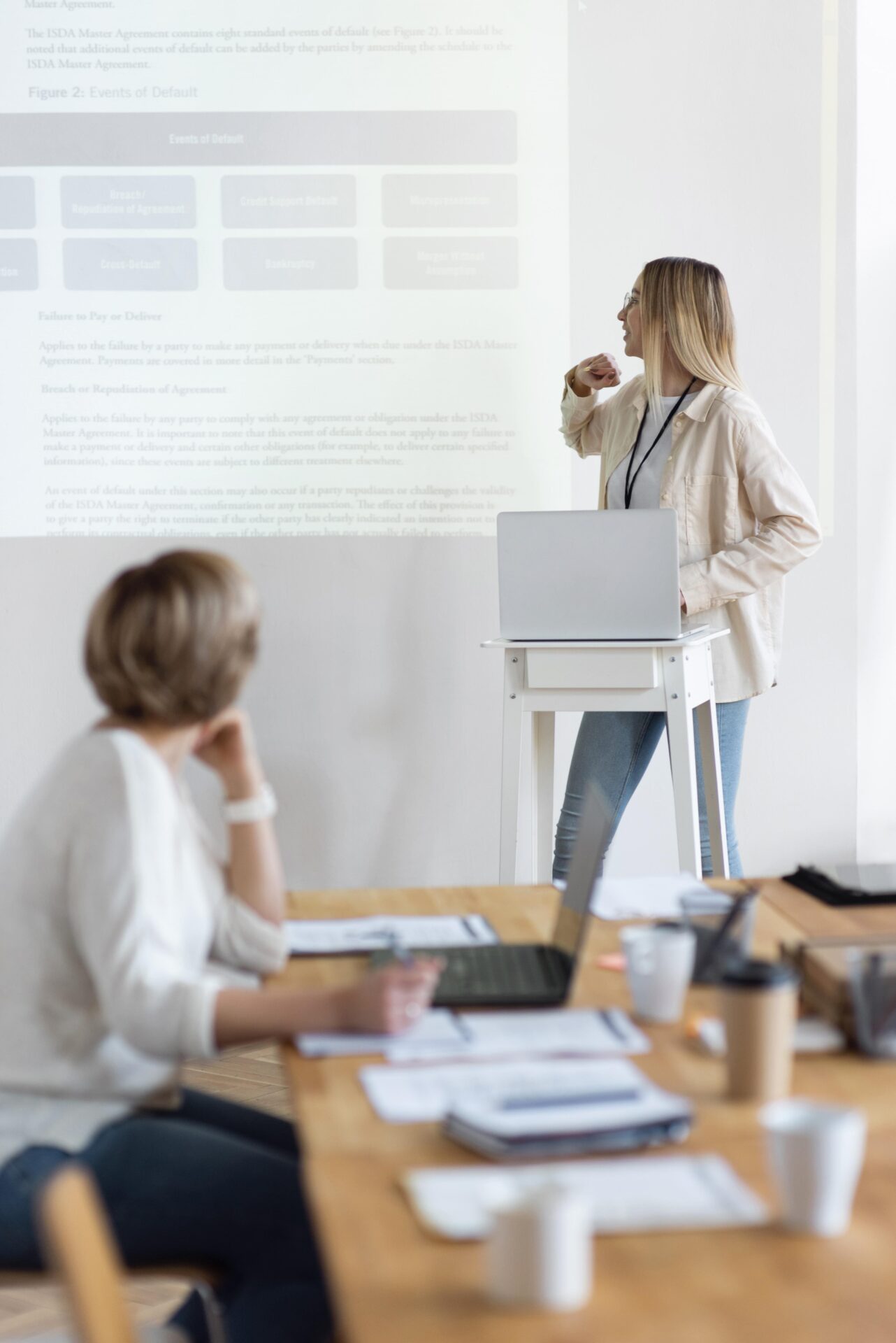 Studentin präsentiert ihre Arbeit vor einem Professor, unterstützt durch Delta Lektorat Coaching.